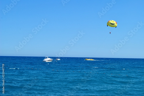 parachute, sea, sport, sky, water, beach, parasailing, ocean, flying, blue, fly, kite, wind, boat, fun, summer, extreme, paragliding, sports, surf, surfing, parasail, travel, kiteboarding, air