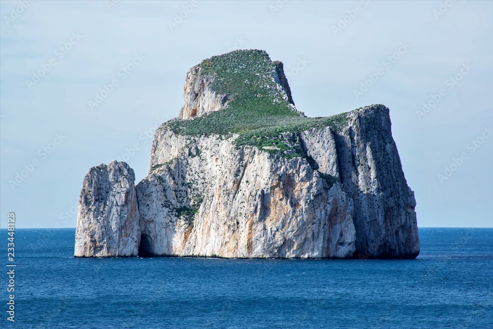 Suggestiva cornice scenografica dell'insenatura di Masua, con vista sull’Imponente roccia del Pan di Zucchero, lungo la costa dell’Iglesiente a sud ovest della Sardegna, Italia.
