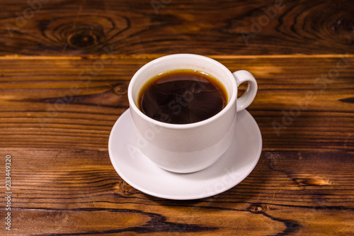 Cup of dark coffee on wooden table