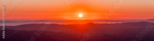 Fiery sunset over a sea of clouds as seen from the top of Mt Diablo, north San Francisco bay area, California (some of San Francisco's buildings visible under a layer of clouds)