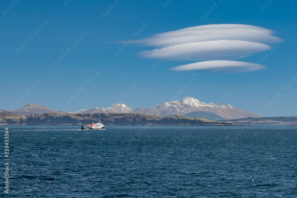 Ferry sailing between Oban and the Isle of Mull with snow capped highland peaks in the background Ferry sailing between Oban and the Isle of Mull with snow capped highland peaks in the background