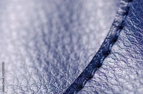 Blue leather material textile fabric bag accessory firmware stitches macro on blur background © Kabardins photo