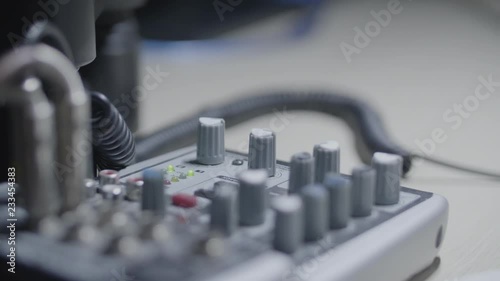 Sound engineer / Producer / musician rotates a knob of a sound mixer in the studio photo