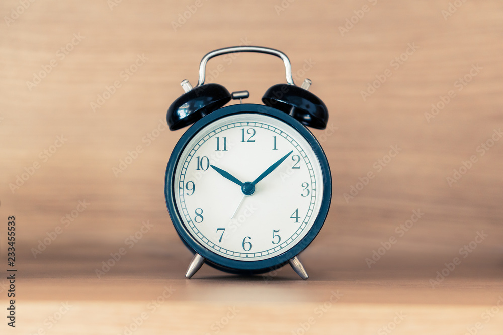 Black alarm clock on the headboard bed shelf with sunlight from the window in the morning, time deadline concept vintage minimal design Black alarm clock on the headboard bed shelf with sunlight from the window in the morning, time deadline concept vintage minimal design