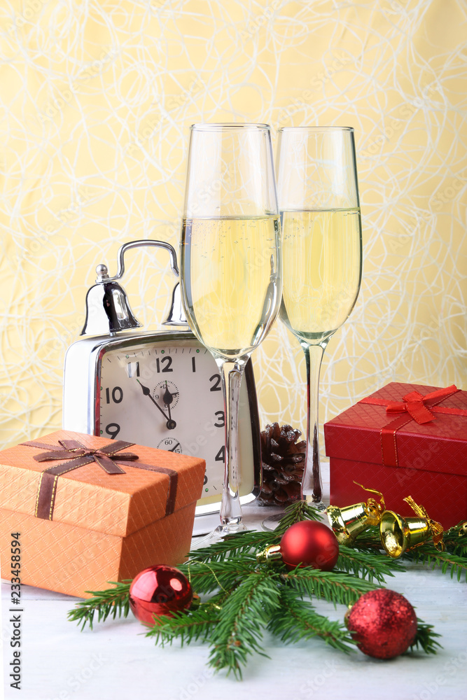 New Year or Christmas decorations with glasses wine, gift boxes, candles and balls. greeting card. Selective focus, copy space. New Year or Christmas decorations with glasses wine, gift boxes, candles and balls. greeting card. Selective focus, copy space.