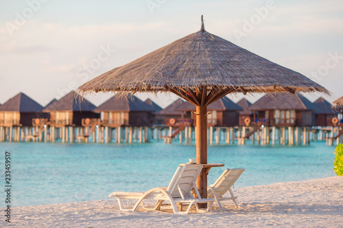 Fototapeta Naklejka Na Ścianę i Meble -  White lounge chairs on a beautiful tropical beach at Maldives