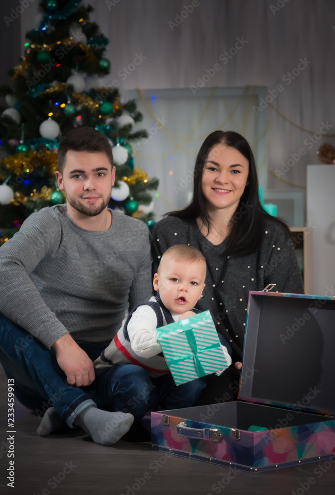 Happy family of three with little boy o Christmas with decorations Happy family of three with little boy o Christmas with decorations