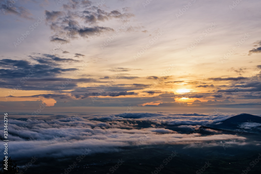 Beautiful nature landscape the sun is above the sea fog that covers the mountains and bright sky during sunrise in the winter at viewpoint of Phu Ruea National Park, Loei province, Thailand.