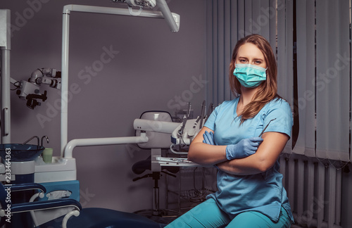 Female dentist sitting with her arms crossed in her dentist office.