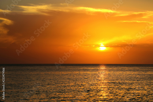 Colorful empty seascape with shiny sea over cloudy sky and sun during sunset in Cozumel  Mexico