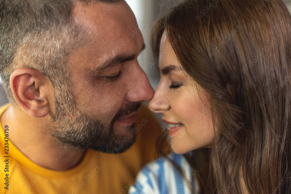 Close up of happy man and woman making romantic photo with closed eyes while touching each other noses Close up of happy man and woman making romantic photo with closed eyes while touching each other noses