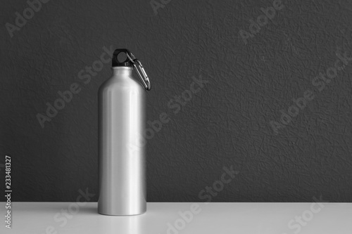 Aluminum water bottle for sports on gray background. Space for text photo