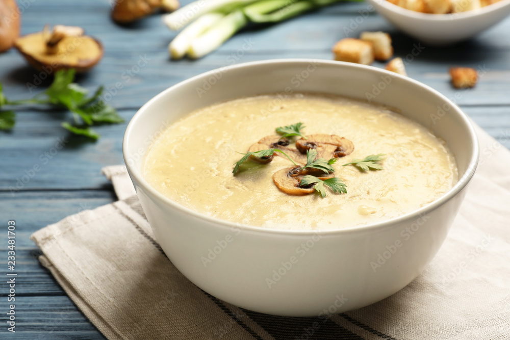 Bowl of fresh homemade mushroom soup on wooden table Bowl of fresh homemade mushroom soup on wooden table