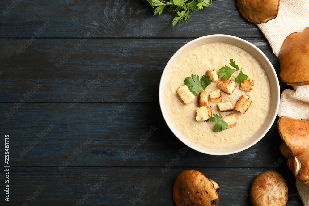 Flat lay composition with bowl of fresh homemade mushroom soup and space for text on wooden background Flat lay composition with bowl of fresh homemade mushroom soup and space for text on wooden background