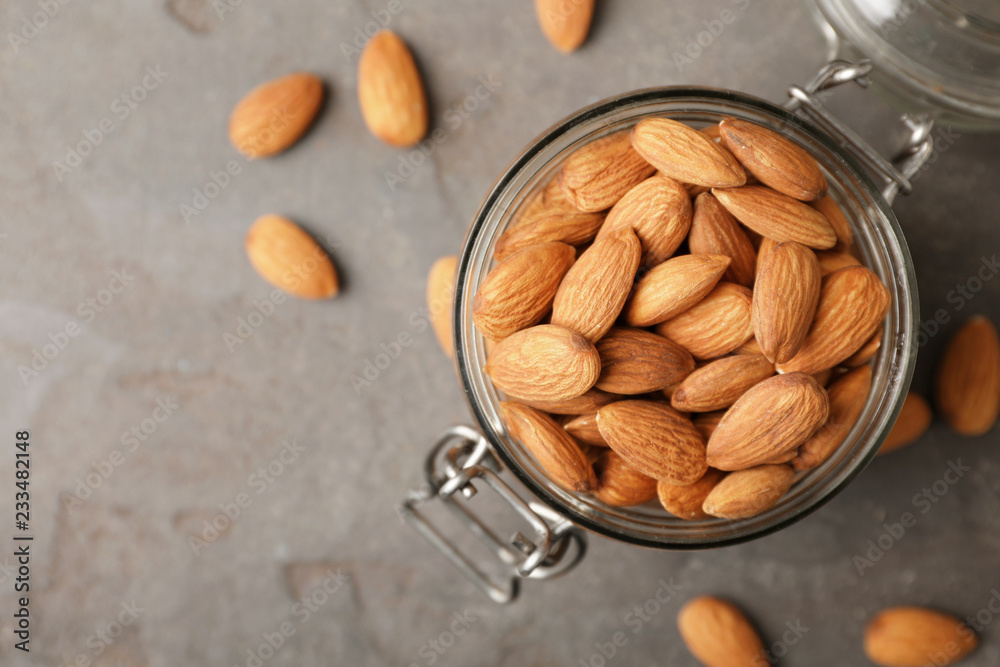 Tasty organic almond nuts in jar and space for text on table, top view Tasty organic almond nuts in jar and space for text on table, top view