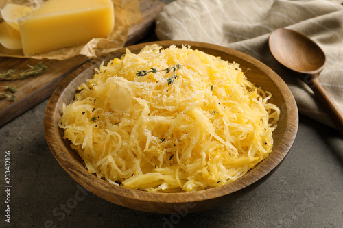 Bowl with cooked spaghetti squash on gray table