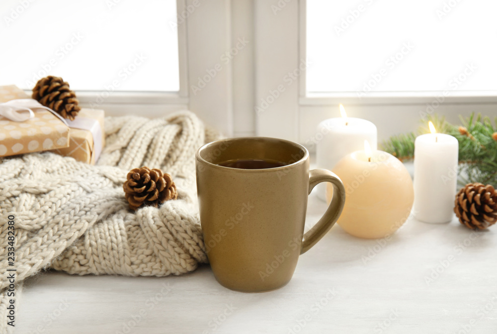 Composition with cup of hot winter drink near window. Cozy season