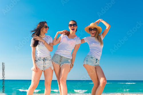 Tres mujeres muy sexys con camiseta blanca saltando y disfrutando un día de verano. © ismel leal