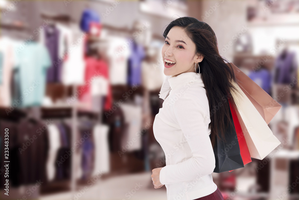 cheerful woman holding shopping bag at mall