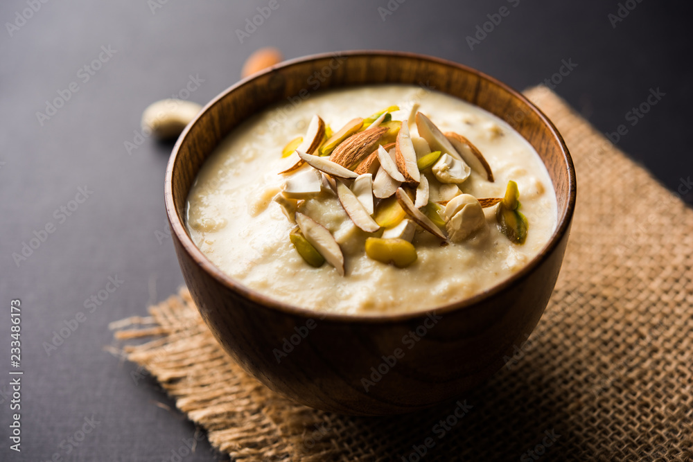 Sweet Rabdi or Lachha Rabri or basundi, made with pure milk garnished with dry fruits. Served in a bowl over moody background. Selective focus Sweet Rabdi or Lachha Rabri or basundi, made with pure milk garnished with dry fruits. Served in a bowl over moody background. Selective focus