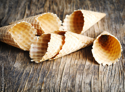 Sweet wafer cone for ice cream on wooden background.