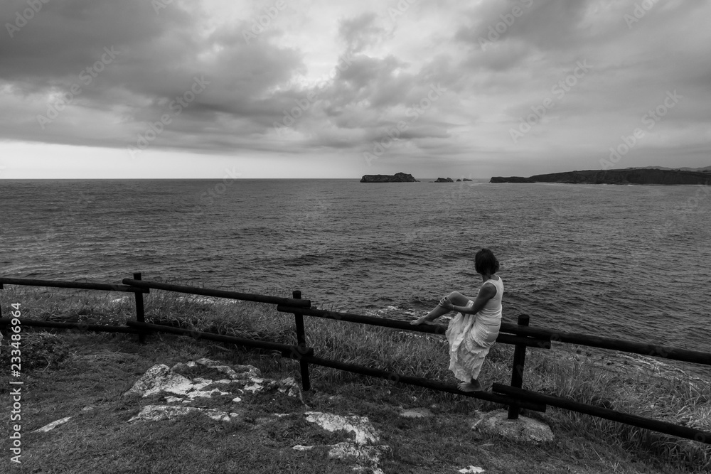 Fototapeta premium Mujer mirando el mar en Suances, Cantabria, España