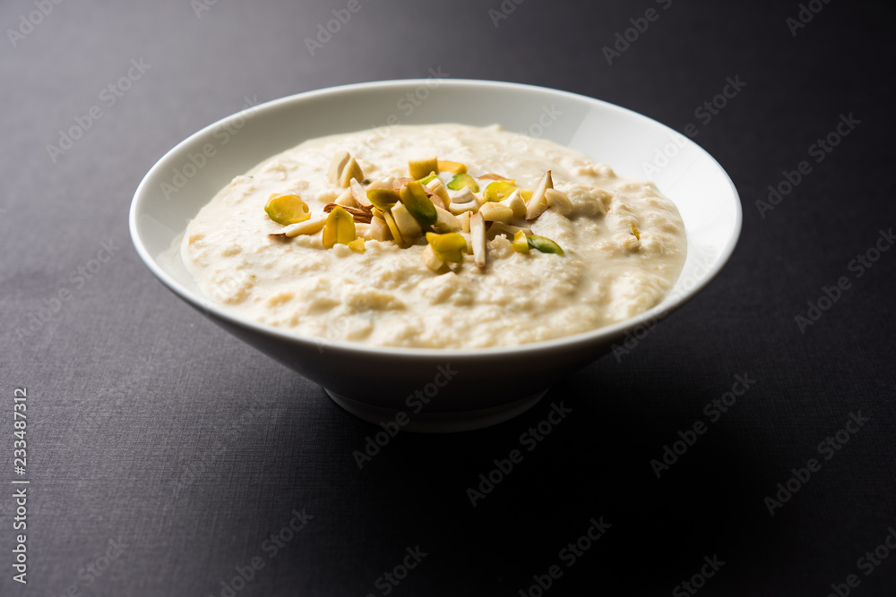 Sweet Rabdi or Lachha Rabri or basundi, made with pure milk garnished with dry fruits. Served in a bowl over moody background. Selective focus Sweet Rabdi or Lachha Rabri or basundi, made with pure milk garnished with dry fruits. Served in a bowl over moody background. Selective focus