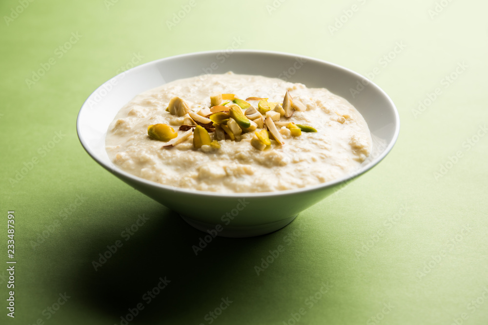 Sweet Rabdi or Lachha Rabri or basundi, made with pure milk garnished with dry fruits. Served in a bowl over moody background. Selective focus Sweet Rabdi or Lachha Rabri or basundi, made with pure milk garnished with dry fruits. Served in a bowl over moody background. Selective focus