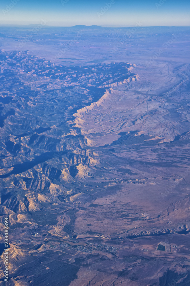 Aerial view of topographical Rocky Mountain landscapes on flight over Colorado and Utah during autumn. Grand sweeping views of rivers, mountain and landscape patterns. Top view, Rockies and Wasatch Fr