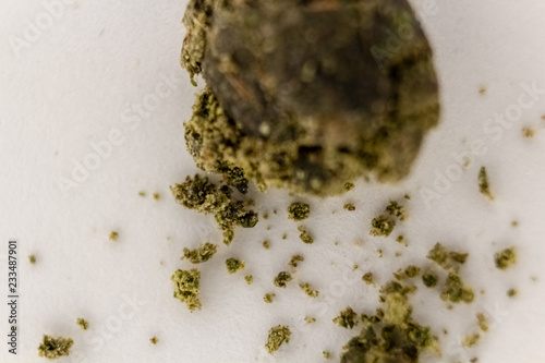Obraz na płótnie Ball of marijuana sift crumbling on a white background. w salonie