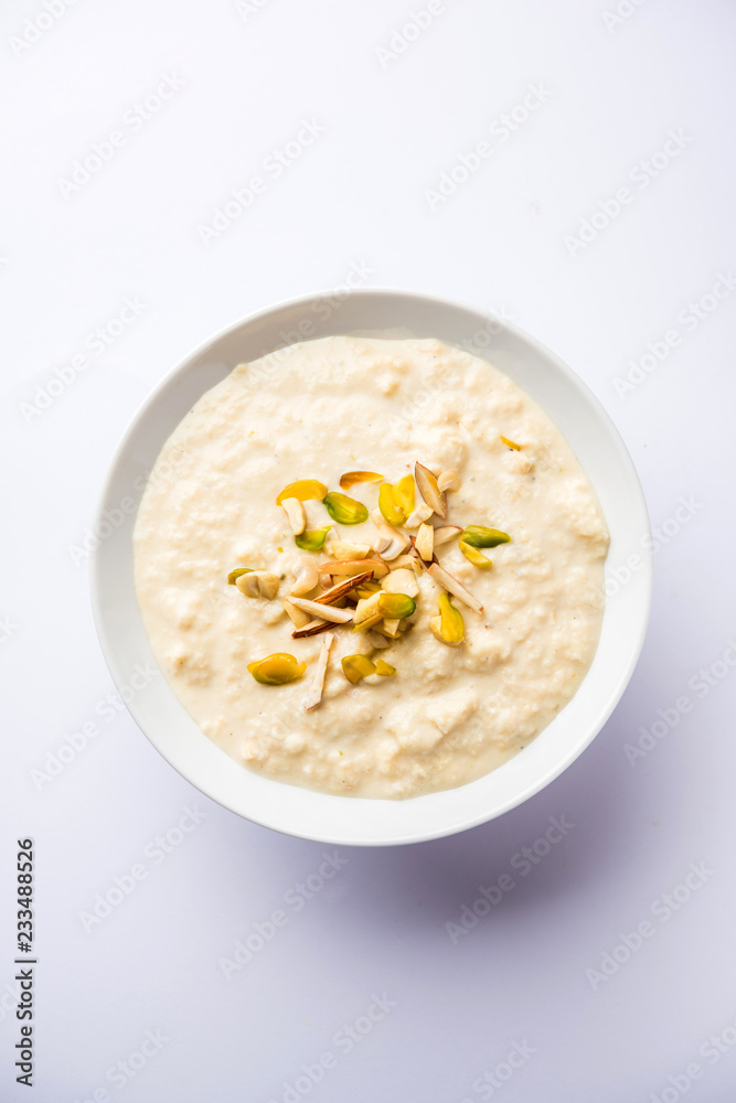 Sweet Rabdi or Lachha Rabri or basundi, made with pure milk garnished with dry fruits. Served in a bowl over moody background. Selective focus Sweet Rabdi or Lachha Rabri or basundi, made with pure milk garnished with dry fruits. Served in a bowl over moody background. Selective focus
