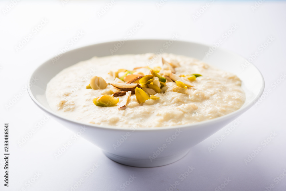 Sweet Rabdi or Lachha Rabri or basundi, made with pure milk garnished with dry fruits. Served in a bowl over moody background. Selective focus Sweet Rabdi or Lachha Rabri or basundi, made with pure milk garnished with dry fruits. Served in a bowl over moody background. Selective focus