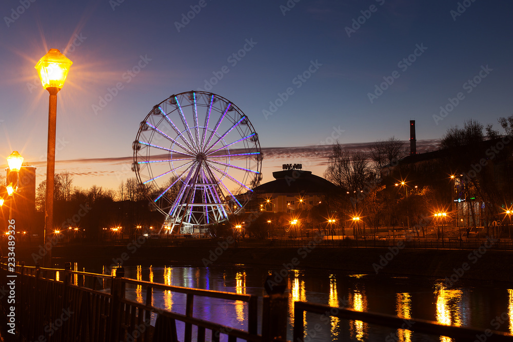 Ferris wheel on the river embankment in the evening