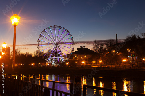 Ferris wheel on the river embankment in the evening