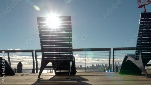 Sun streaming through deck chairs overlooking Vancouver harbor and cityscape. photo