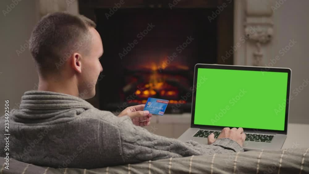 Young man making purchases on a laptop online Young man making purchases on a laptop online