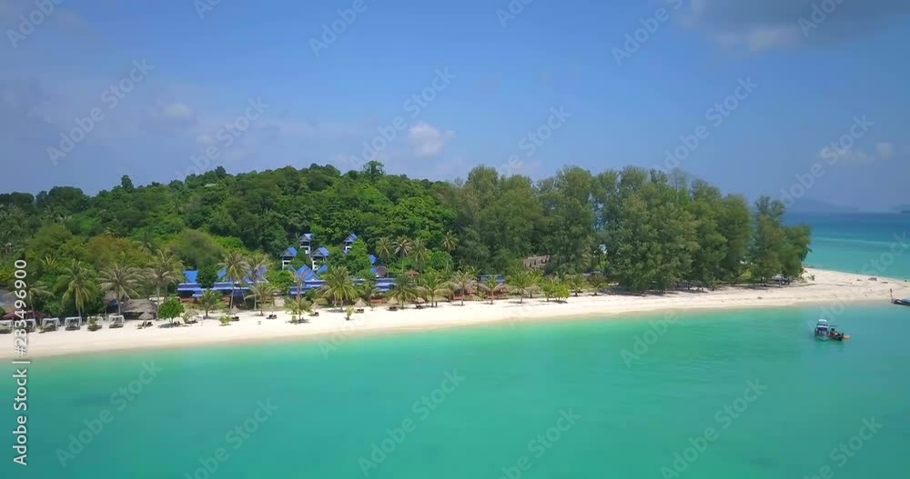 Forward advancing aerial drone view over clear blue tropical ocean approaching white sand beach and beachfront resort on sunny day in Ko Lipe, Thailand. 4k 1.9:1 23.976fps Forward advancing aerial drone view over clear blue tropical ocean approaching white sand beach and beachfront resort on sunny day in Ko Lipe, Thailand. 4k 1.9:1 23.976fps