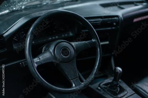 Old leather stylish sport steering wheel in old school sport car with dark interior © Aleksander