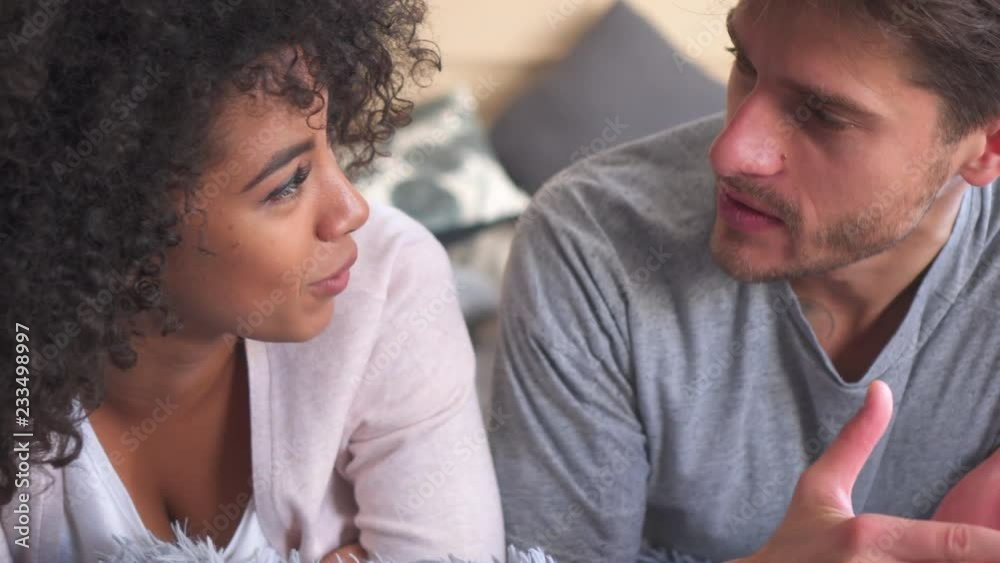 Mixed race couple talking in bed Mixed race couple talking in bed