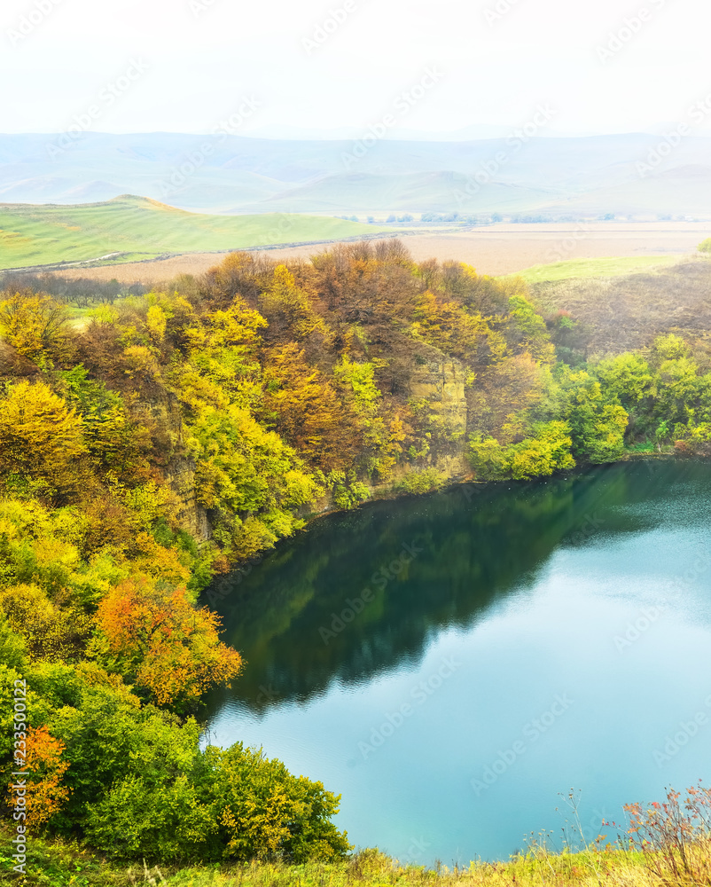 Mountain lake landscape. Reflection with autumn trees.The lake is karst origin, Shadhurey, North Caucasus, Kabardino Balkariya. 