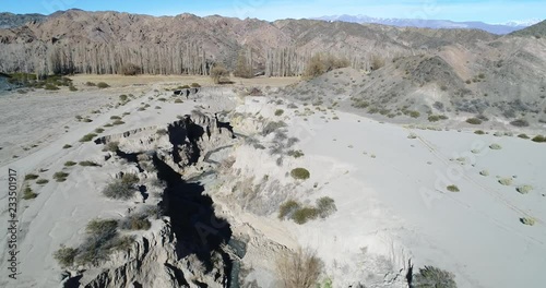 Flying over ravine of El Leoncito river. Genearl view of valley and mountains and poplars at background. National Park El Leoncito, San Juan, Argentina 