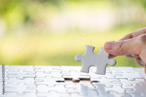 Hand put the last piece of jigsaw puzzle to complete the mission, Business solutions, success and strategy concept photo