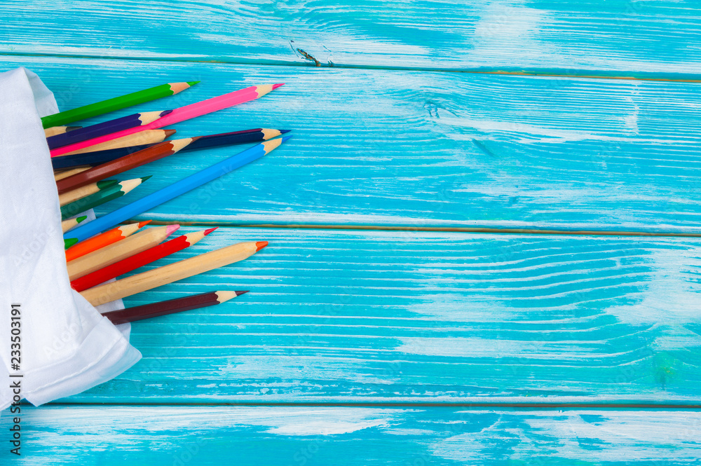 Colorful pencils on a bright blue wooden background