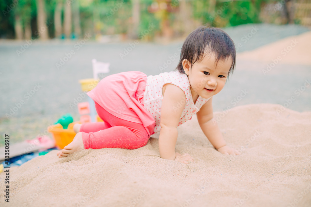 an 1 year old baby playing in the sands. This activity is good for sensory experience and learning by touch their fingers and toes through sand and enjoying its texture. an 1 year old baby playing in the sands. This activity is good for sensory experience and learning by touch their fingers and toes through sand and enjoying its texture.