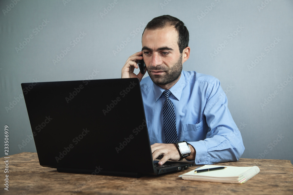 Businessman talking phone and working on laptop. Business concept Businessman talking phone and working on laptop. Business concept