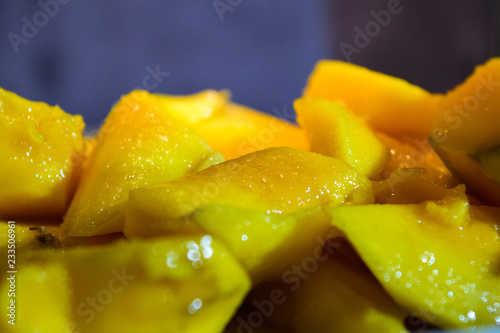 Close-up mango in blue plate on wooden table. Health inspiration concepts. Vintage Background