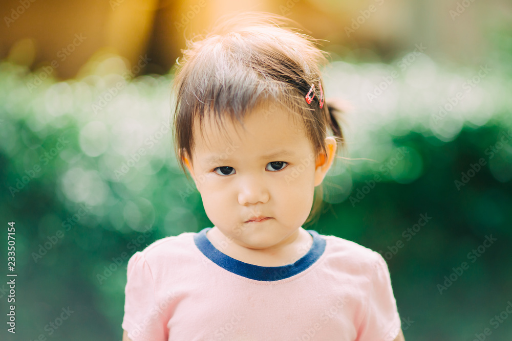 An emotional face of baby who enter the terrible twos period, a two