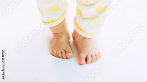 first steps of new born baby, feet of toddler on the white floor.  © nateejindakum