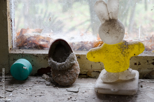 Children's toy and shoes on windowsill in abandoned kindergarten in destroyed village of Kopachi (Chernobyl exclusion zone), Ukraine photo