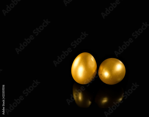 Golden eggs with copy space on black background.
